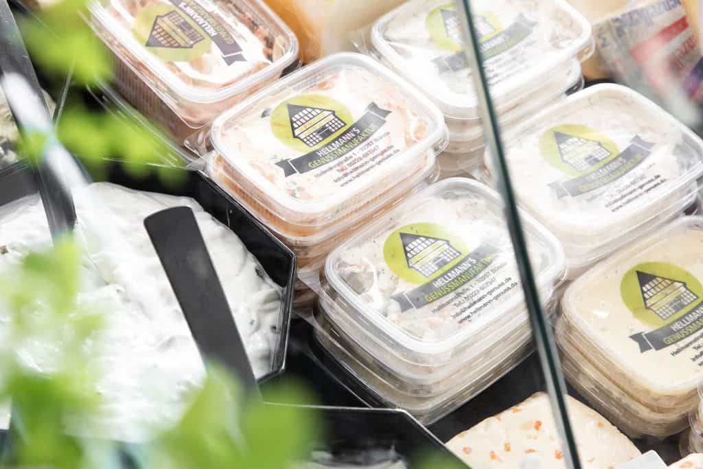 Frischkäse in Bechern, ideal für Snacks und Brotaufstriche, bei Hellmann Genuss erhältlich.